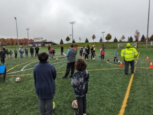 Knight Ryan Grill who lead the soccer challenge championship explaining the rules as participants and supporting families look on